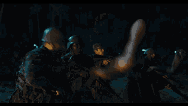 a group of soldiers are standing in front of a large fire