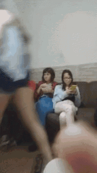 a group of people are sitting on a couch and one of them is holding a phone