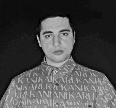 a black and white photo of a man wearing a shirt that says ' karli ' on it