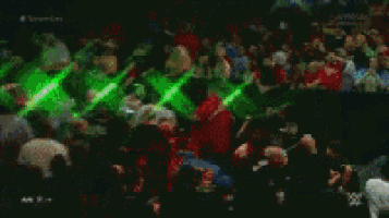 a blurred image of a crowd of people watching a wrestling match .