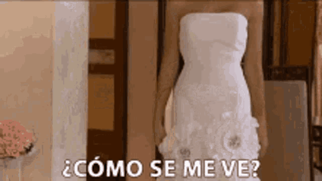 a woman in a white wedding dress is standing in front of a mirror with the words como se me ve written below her