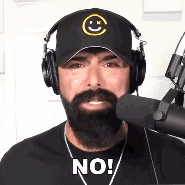 a man with a beard wearing headphones and a hat that says no