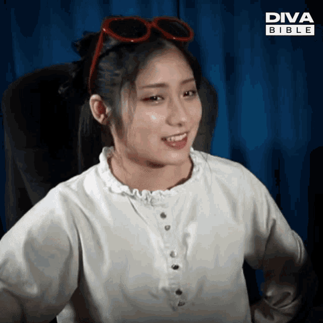 a woman wearing sunglasses and a white shirt with diva bible on the bottom