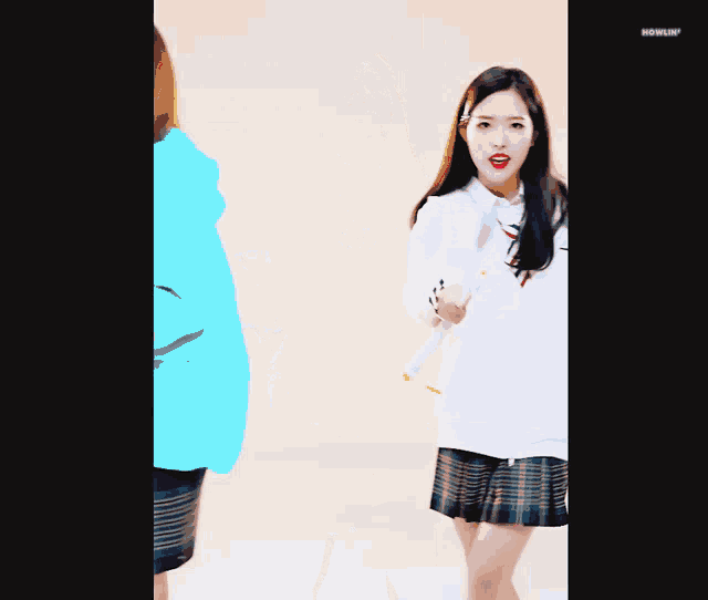 a girl in a plaid skirt is dancing in front of a howlin ' sign