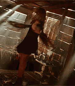 a woman in a black dress is standing in a room