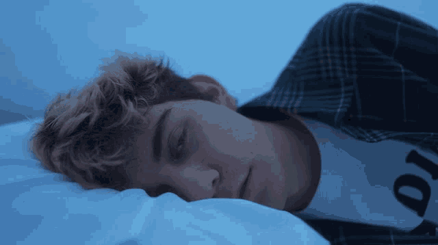a young man is sleeping with his eyes closed and his shirt says 10