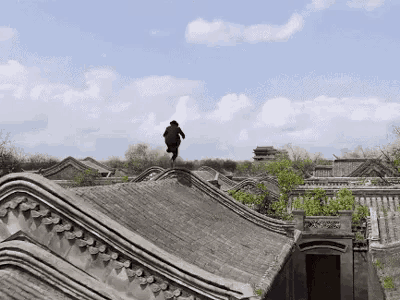 a person is standing on top of a roof in a city .