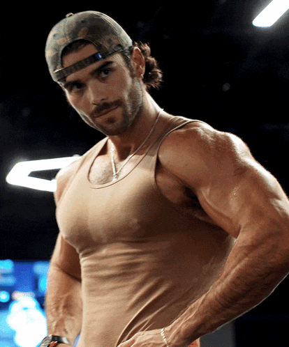 a man wearing a tan tank top and a hat that says ' army ' on it