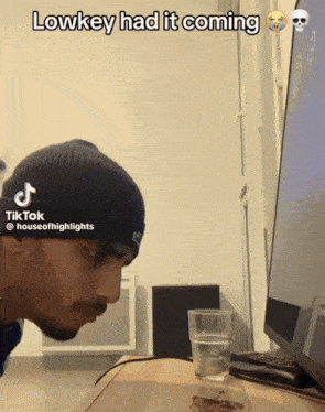 a man in a beanie is looking at a computer screen with a caption that says " lowkey had it coming "