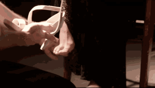 a man is tying a woman 's shoe with tape
