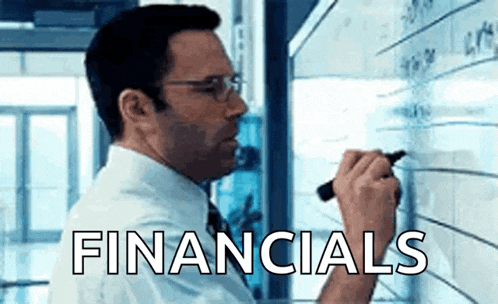 a man is writing on a whiteboard with the word financials written on it