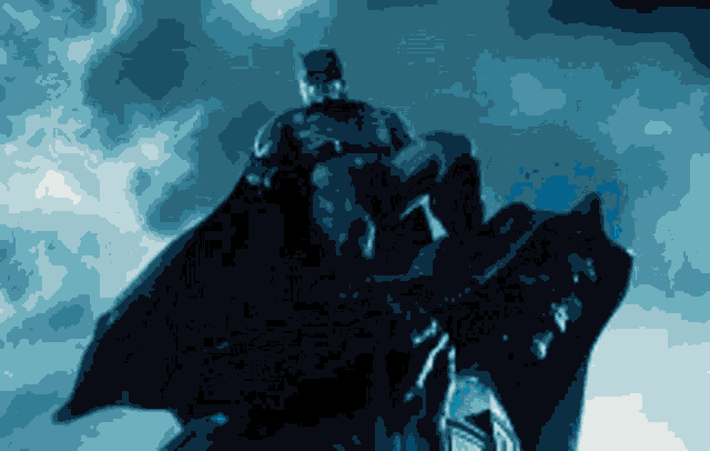 a statue of batman is sitting on top of a building