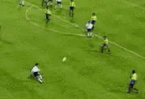 a soccer goalie is jumping to catch a ball in front of a coca cola sign