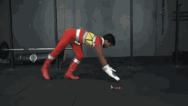 a man in a red power ranger costume does a handstand