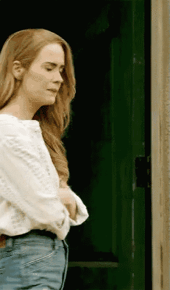 a woman is standing in front of a green door .