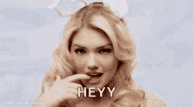 a woman wearing bunny ears is licking her lips and saying heyy