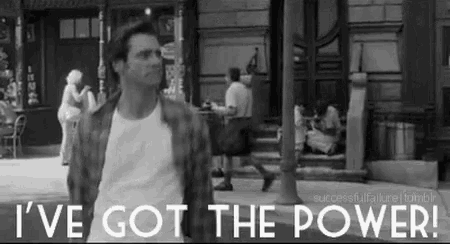 a man is walking down a street with the words `` i 've got the power '' behind him .
