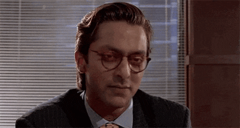 a man in a suit and tie is looking at the camera .