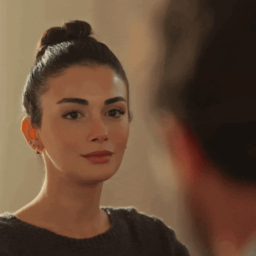 a close up of a woman 's face with a bun