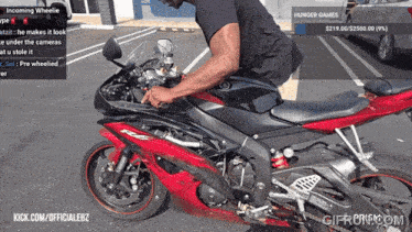 a man on a red motorcycle with hunger games written on the screen