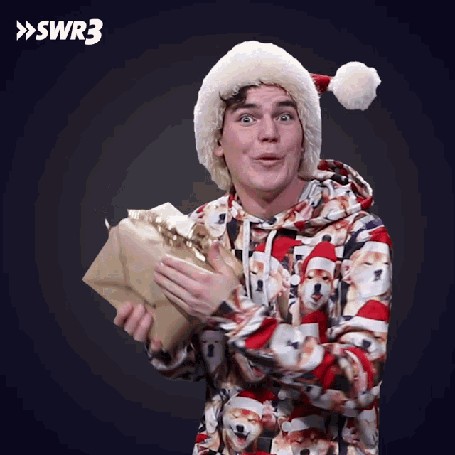 a man wearing a santa hat is holding a gift box