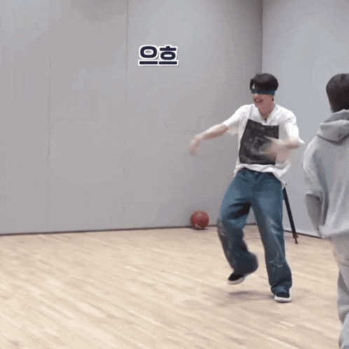 a man in a white shirt and jeans is dancing on a wood floor