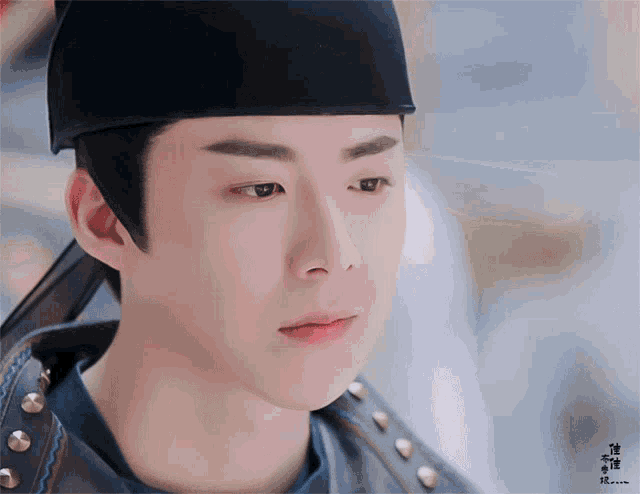 a close up of a man wearing a black hat with chinese writing on it