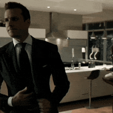 a man in a suit and tie adjusts his tie