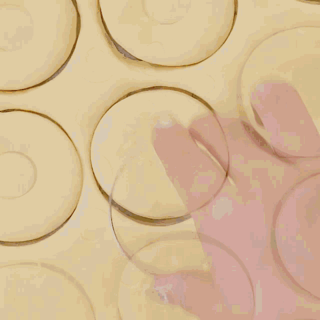 a person is cutting donuts out of dough on a cutting board