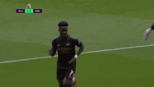 a soccer player wearing a jersey that says emirates is dancing on the field