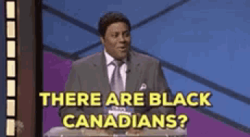 a man in a suit and tie is asking if there are black canadians on a game show .