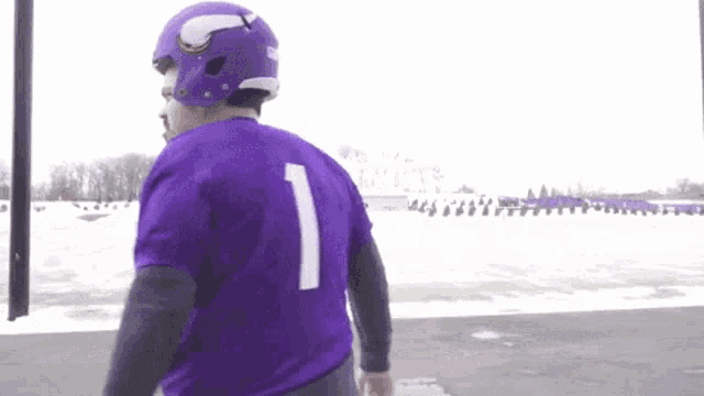 a man wearing a purple jersey with the number one on it