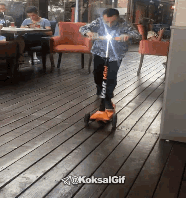 a man riding a volt mini scooter on a deck