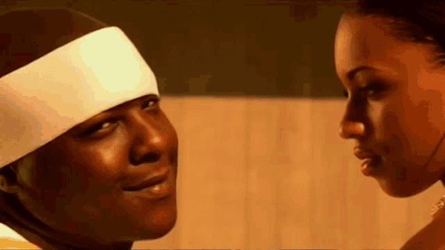 a man wearing a headband looks at a woman
