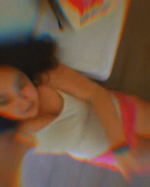 a woman in a white tank top and pink shorts is laying on her back