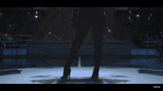 a woman is standing on a stage with a microphone in her hand and the words vevo on the bottom
