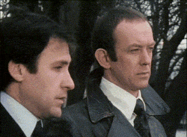 two men are standing next to each other and looking at the camera