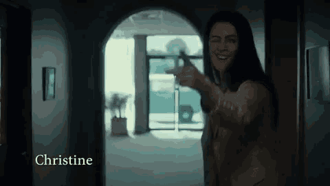 a naked woman is standing in a hallway pointing at the camera and smiling .