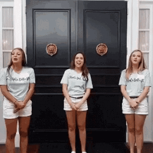 three women standing in front of a black door wearing shirts that say i 'm a bride
