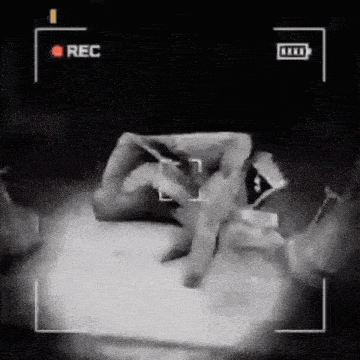 a black and white video of a person holding a piece of paper with the word rec on the bottom