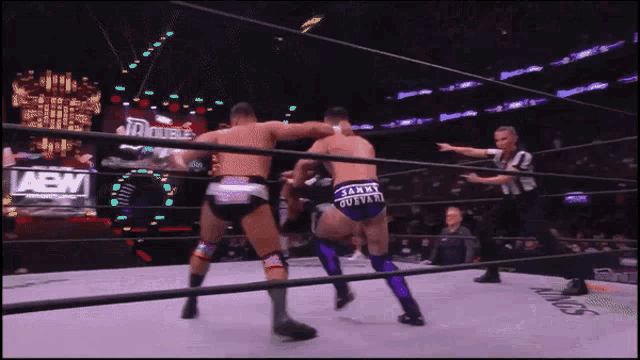two wrestlers are in a ring with the abw logo on the wall