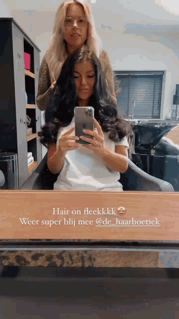 a woman is taking a picture of herself in a mirror while getting her hair done