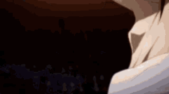 a close up of a person 's face in a dark room with a smile on their face .