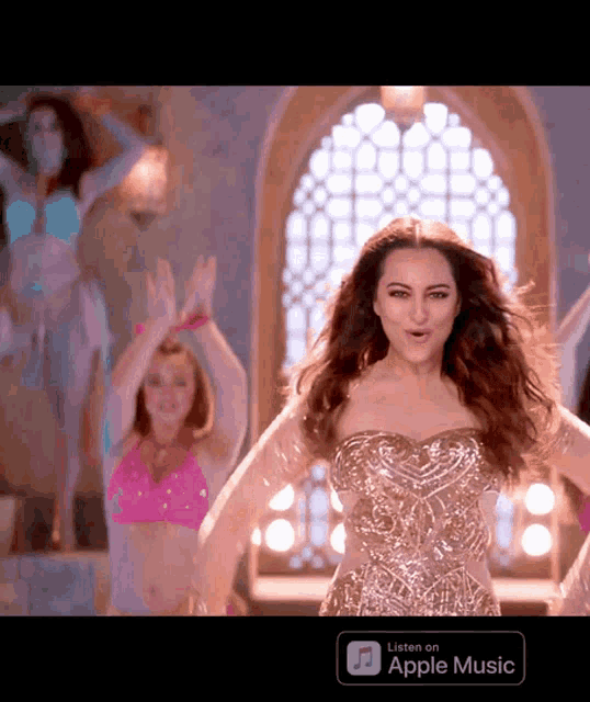 a woman is dancing in front of an apple music app