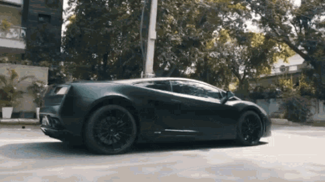 a black lamborghini is parked on the side of the road