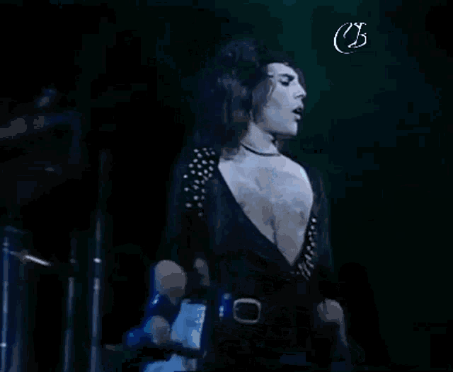 a man is standing on a stage holding a microphone and singing into it .