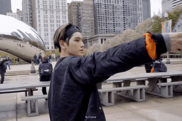 a man wearing a headband and a black jacket is taking a picture