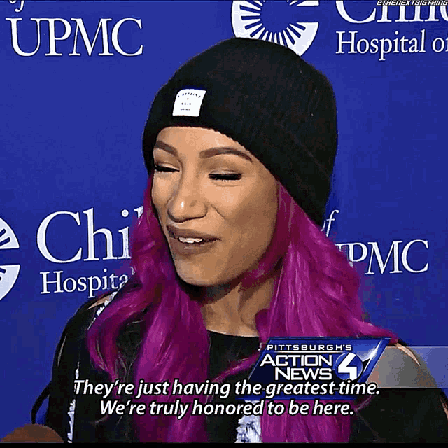 a woman with purple hair and a black hat is being interviewed by pittsburgh 's action news