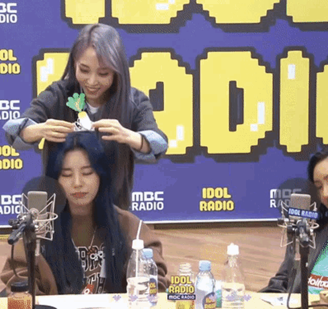 a woman is getting her hair done at idol radio
