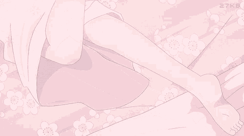 a girl is laying on a bed with a pink pillow and flowers on it .